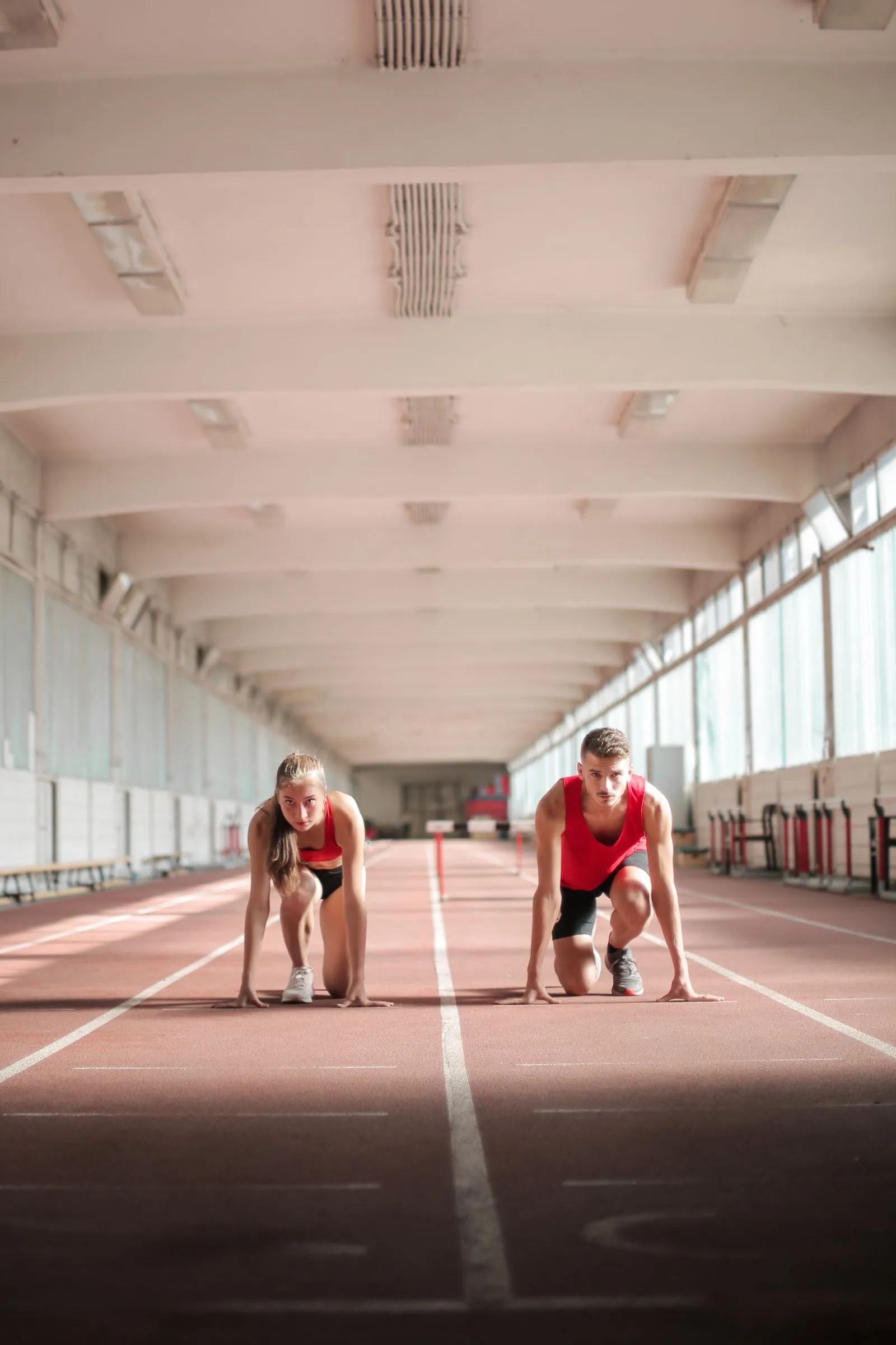 Dos atletas en posición de salida sobre una pista de atletismo